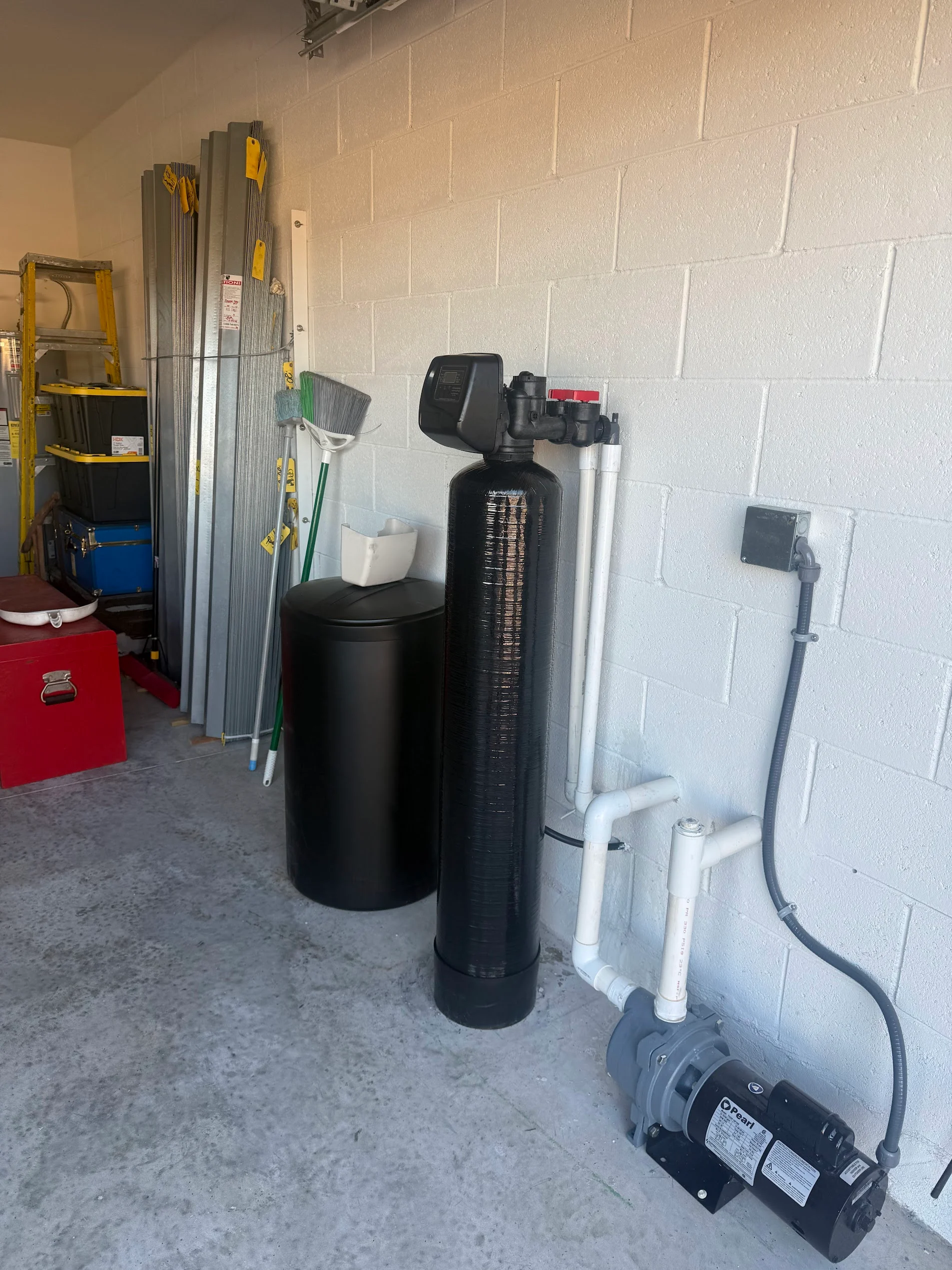 Water softener, filtration tank, pump system, and PVC piping installation in basement