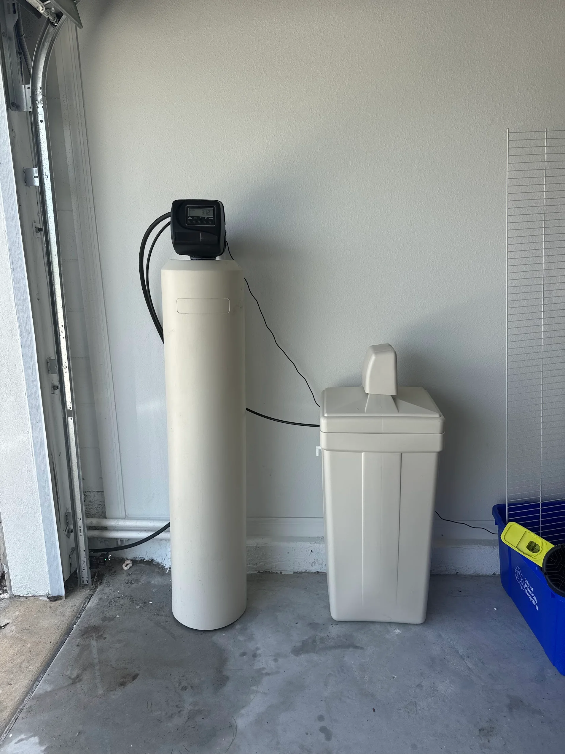 Water softener and brine tank installation with digital control valve in garage
